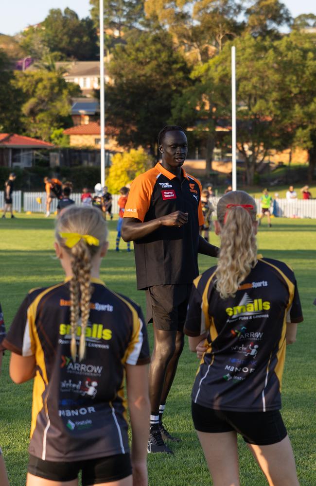 GWS Giants defender Leek Aleer takes kids through an Aussie rules drill at Baulkham Hills on Wednesday. Picture: GWS