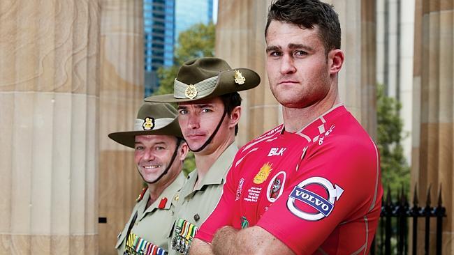 Reds captain James Horwill receives the Anzac jersey from Brigadier Greg Bilton (left) and Corporal Seamus Donaghue.