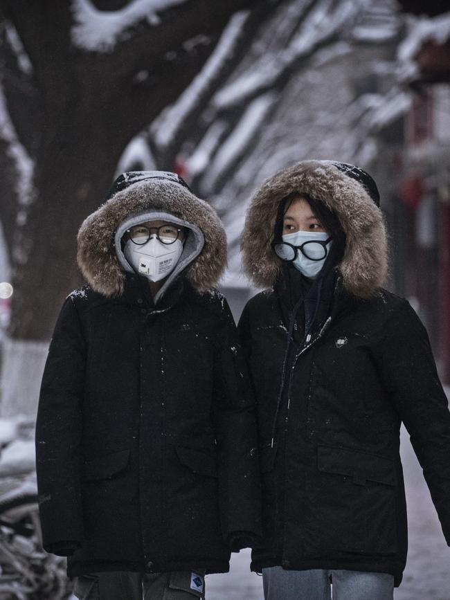 Chinese women wear protective masks as they walk in the street in Beijing, China. (Photo by Kevin Frayer/Getty Images)