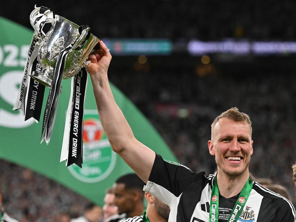 Dan Burn celebrates with the trophy after Newcastle’s English League Cup victory.