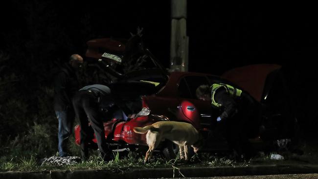 Tasmanian police inspect a  car out the front of a Magra property on Back River Road.  Picture: Zak Simmonds