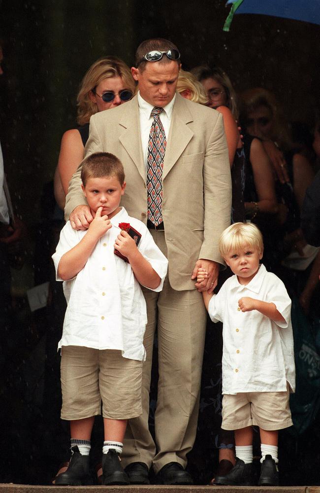 Kevin Walters with sons Jack (6) and Billy (4) as wife Kim's coffin is taken from the church at Toowoomba.