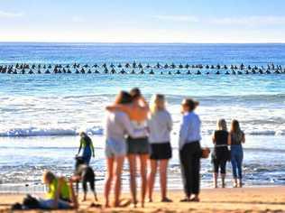 FAREWELL FOR A FRIEND: Hundreds gathered at Mudjimba Beach yesterday to paddle out in honour of Mike Daniell. Onlookers were touched as surfers formed a circle in the ocean for their friend. Picture: John McCutcheon