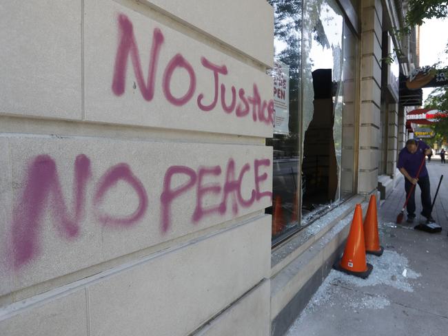 A worker sweeps broken glass from in front of a Dunkin Donuts store damaged during protests over the deaths of George Floyd and Breonna Taylor in Louisville, Kentucky. Picture: AP Photo