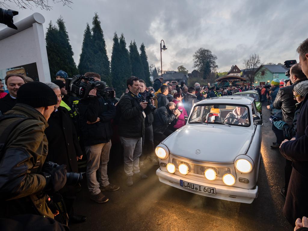 People arrive in East German-era Trabant cars at a former border crossing to recreate scenes from 30 years ago when East Germans lined up to drive into the West. Picture: Jens Schlueter/Getty Images.