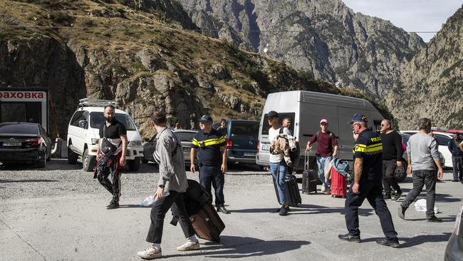 Travellers walk towards the road to Tbilisi after crossing the Verkhni Lars customs checkpoint between Georgia and Russia on Wednesday. Picture: Getty Images