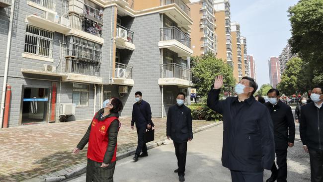 Chinese President Xi Jinping waves to residents who are quarantined at home as he pays a visit to a community in Wuhan in central China's Hubei province. The province at the center of China's virus outbreak is allowing factories and some other businesses to reopen. Picture: Ju Peng/Xinhua via AP