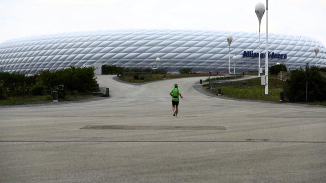 A jogger passes the German Bundesliga soccer club stadium Allianz Arena' in Munich. All major events in Germany are suspended due to the coronavirus outbreak and the Bundesliga's plans to restart in May are meeting increased opposition. Picture: Matthias Schrader/AP