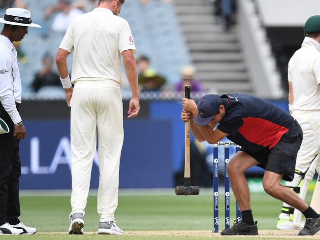 A groundsman hits the pitch with a sledgehammer on day five of the Boxing Day test match between Australia and England at the MCG in Melbourne, Saturday, December 30, 2017. (AAP Image/Julian Smith) NO ARCHIVING, EDITORIAL USE ONLY, IMAGES TO BE USED FOR NEWS REPORTING PURPOSES ONLY, NO COMMERCIAL USE WHATSOEVER, NO USE IN BOOKS WITHOUT PRIOR WRITTEN CONSENT FROM AAP