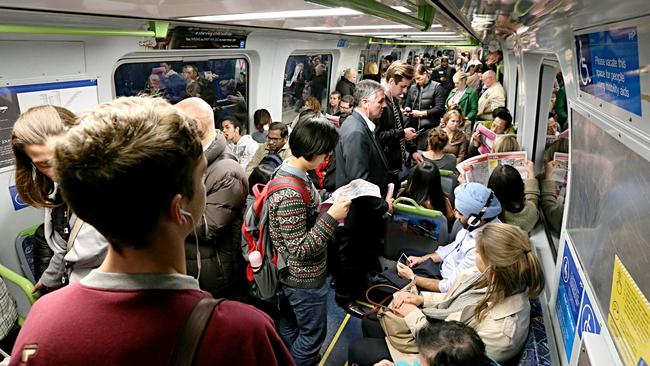 Commuters cram on to a train during peak hour.