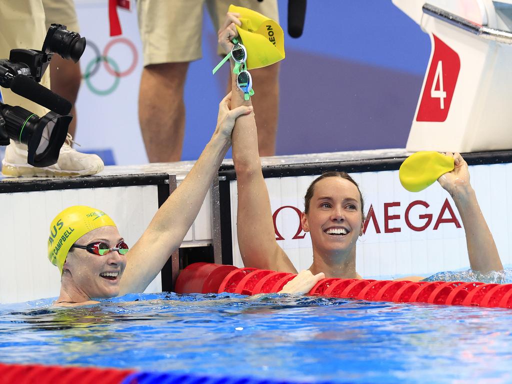 Cate Campbell raises teammate Emma McKeon’s arm as they celebrate gold and bronze wins in the Women's 100m Freestyle final. Picture: Adam Head