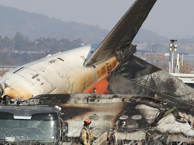 MUAN-GUN, SOUTH KOREA - DECEMBER 29: Firefighters check near the wreckage of a passenger plane at Muan International Airport on December 29, 2024 in Muan-gun, South Korea. A plane carrying 181 people, Jeju Air Flight 7C2216, crashed at Muan International Airport in South Korea after skidding off the runway and colliding with a wall, resulting in an explosion. Early reports said that at least 120 people had died. (Photo by Chung Sung-Jun/Getty Images)