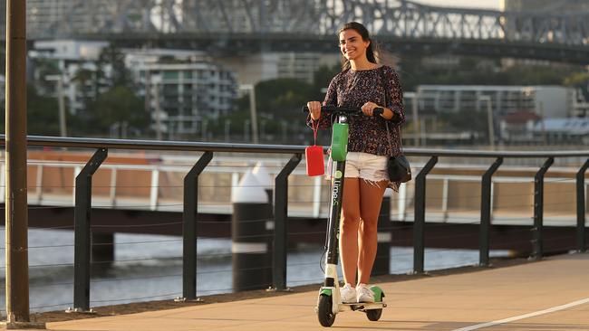 Tourist Beatriz Mello 26, from Brazil, ride a Lime e-scooter along the Brisbane River. Picture: Lyndon Mechielsen/The Australian