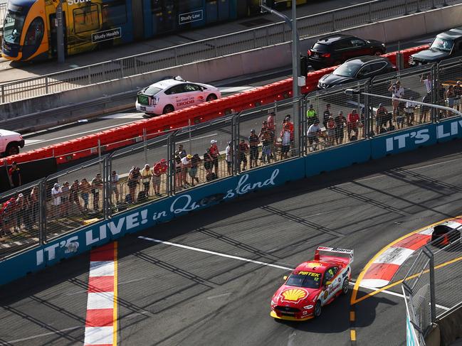 DJR Team Penske driver Fabian Coulthard competes in the Gold Coast 600 Supercars race, while the G Link tram and traffic on the Gold Coast Highway drive past the Surfers Paradise circuit. PICTURE: BRENDAN RADKE