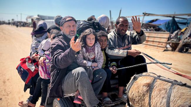 Palestinians set out to Khan Yunis with their belongings, from Rafah's Tel al-Sultan area after it was encircled by Israeli forces on March 23, 2025. Israel's military pressed ground operations across the Gaza Strip on March 23, encircling part of Rafah city including the Tel al-sultan area, nearly a week into a renewed assault on the Palestinian territory. (Photo by AFP)