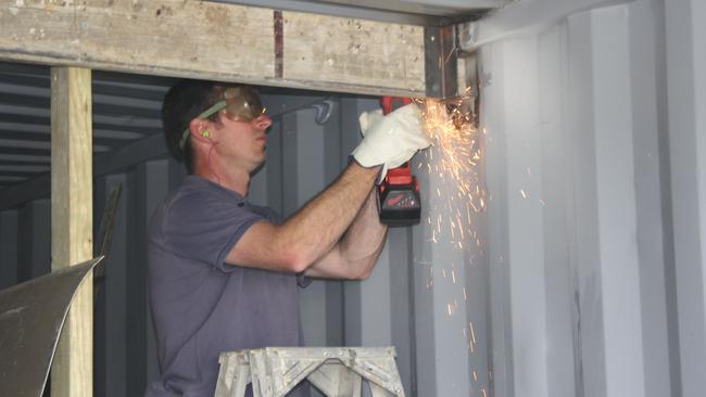 A police officer looks for drugs hidden in one of 110 sea containers used to traffick a massive haul. Picture: NSW Police