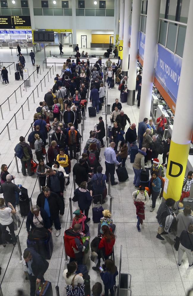 Passengers queue for flights at Gatwick Airport as the airport and airlines work to clear the backlog of flights delayed by a drone incident earlier in the week. Picture: AP