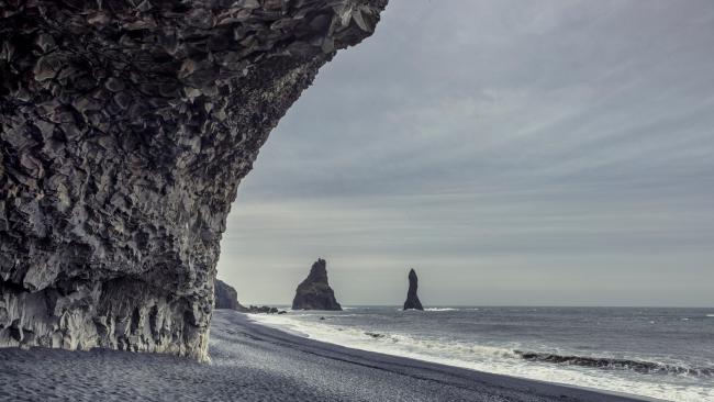Best beach in Iceland? Reynisfjara
World-famous for its striking black sand aesthetic and towering stacks of basalt, Reynisfjara on the island’s south coast is most certainly on the no-swim list amongst beaches (to the degree that you should keep far back from the waves to avoid the sudden far-reaching ones that can pull unwitting beachgoers in). But with such a dramatic landscape (and the chance to see puffins in summer) it is well worth the visit.