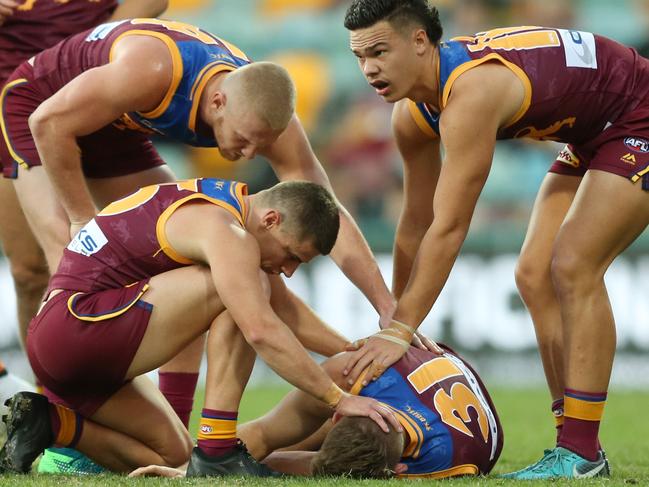 BRISBANE, AUSTRALIA - JUNE 23: Team mates and staff surround Harris Andrews of the Lions as he is taken from the ground after he collided with Jeremy Cameron of the Giants during the round 14 AFL match between the Brisbane Lions and the Greater Western Sydney Giants at The Gabba on June 23, 2018 in Brisbane, Australia. (Photo by Jono Searle/Getty Images)