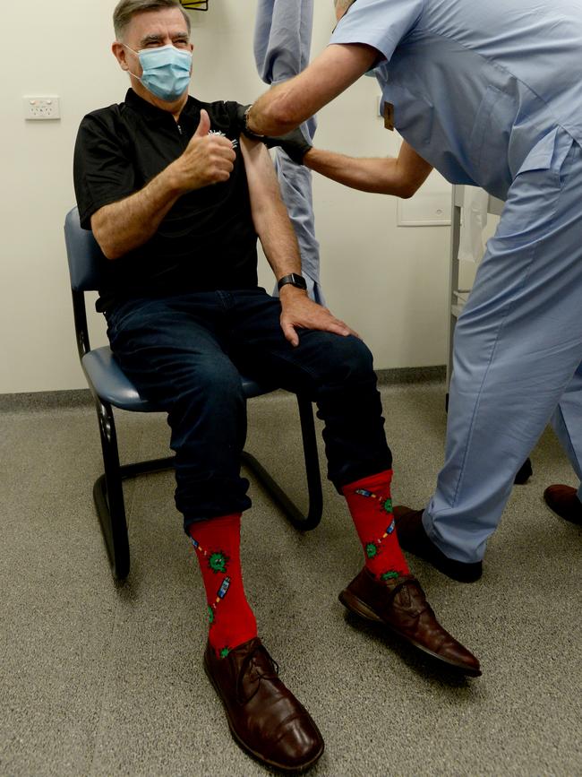 Professor Brendan Murphy shows off his COVID-themed socks as he receives the AstraZeneca vaccine at the Carrum Downs Respiratory Clinic. Picture: Andrew Henshaw