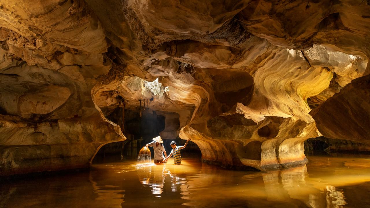 A father and son catch fish using a bamboo basket trap inside a karst cave in South Vietnam during the monsoon season. Cave fishing is only possible during this season when the cave chamber is flooded with rainwater. Picture: Natnattcha Chaturapitamorn/Pink Lady® Food Photographer of the Year