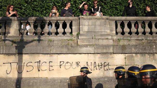 French riot police walk past graffiti reading ‘Justice for Nahel’ at Place de la Concorde in Paris. Picture: AFP