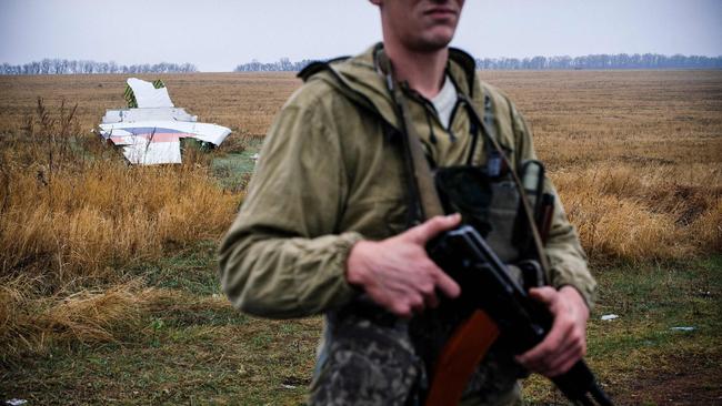 (FILES) In this file photo taken on November 10, 2014 a pro-Russian gunman stands guard next to parts of the Malaysia Airlines Flight MH17 at the crash site near the village of Hrabove (Grabovo), some 80 kms east of Donetsk. - A court in Ukraine on September 5, 2019 released from pre-trial detention a man suspected of involvement in the downing of flight MH17, amid speculation he may be used in a prisoner swap with Russia. Ukraine captured Vladimir Tsemakh, accused of fighting for pro-Russian separatists, in June, but he is believed to be a person of interest in the downing of MH17. European lawmakers described him as a "key suspect" and asked Kiev to make him available for testimony in the probe. (Photo by Dimitar DILKOFF / AFP)