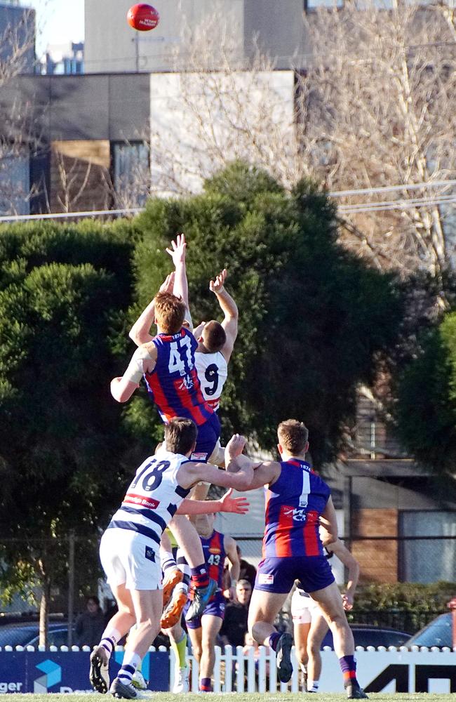 Port’s Michael Wenn springs above Cat Zac Smith in a ruck contest. Pic: Jenny Tserkezidis