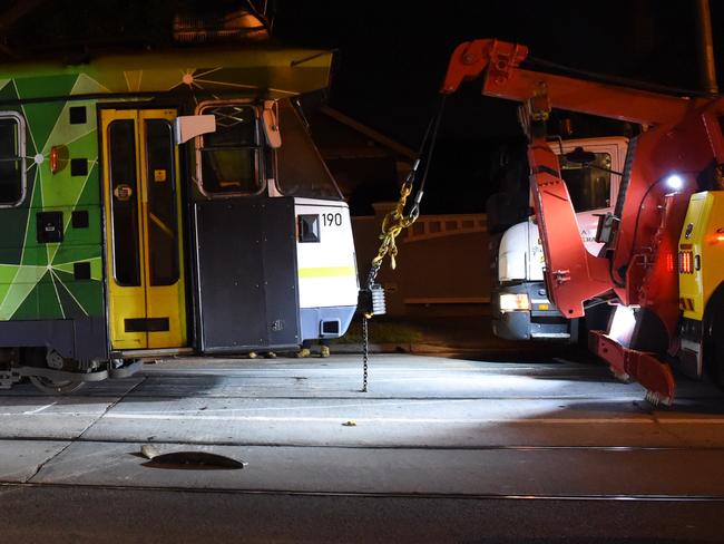 A tram is put back on to the tracks after it smashed into a fire hydrant and derailed in Ascot Vale. Picture: Nicole Garmston