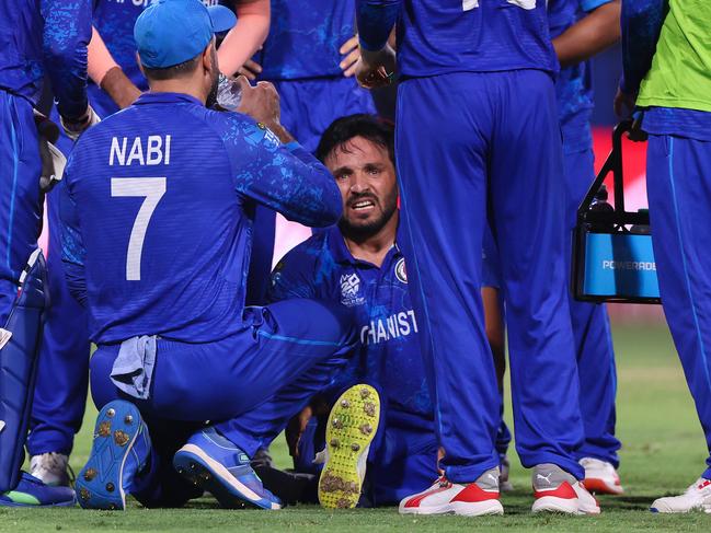 ST VINCENT, SAINT VINCENT AND THE GRENADINES - JUNE 22: Gulbadin Naib of Afghanistan goes down with an injury whilst celebrating with teammates after bowling Pat Cummins of Australia (not pictured) during the ICC Men's T20 Cricket World Cup West Indies & USA 2024 Super Eight match between Afghanistan and Australia at Arnos Vale Ground on June 22, 2024 in St Vincent, Saint Vincent and The Grenadines. (Photo by Darrian Traynor-ICC/ICC via Getty Images)