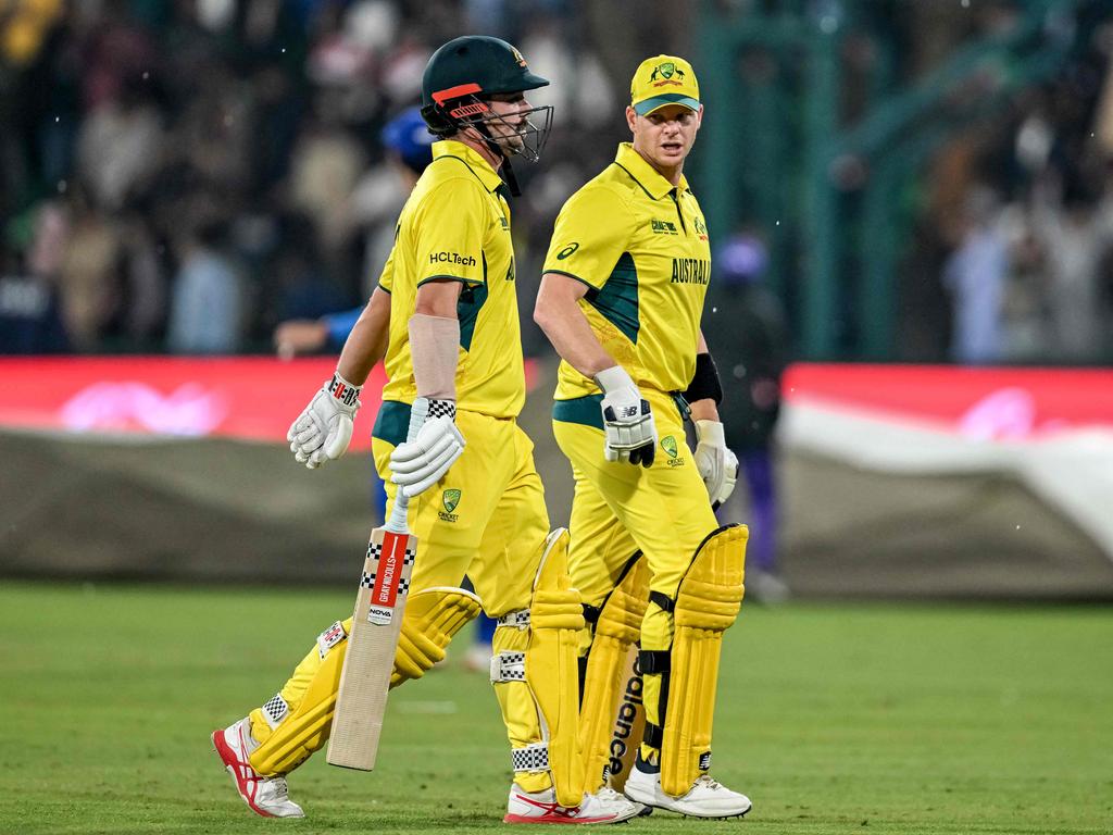 Australia's Travis Head and captain Steve Smith walk back to the pavilion as rain stops play during the match with Afghanistan. Picture: AFP