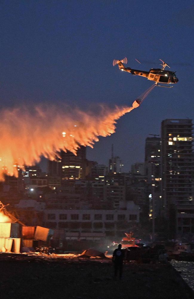 Helicopters try to put out the fire that was still alight into the night at the scene. Picture: AFP