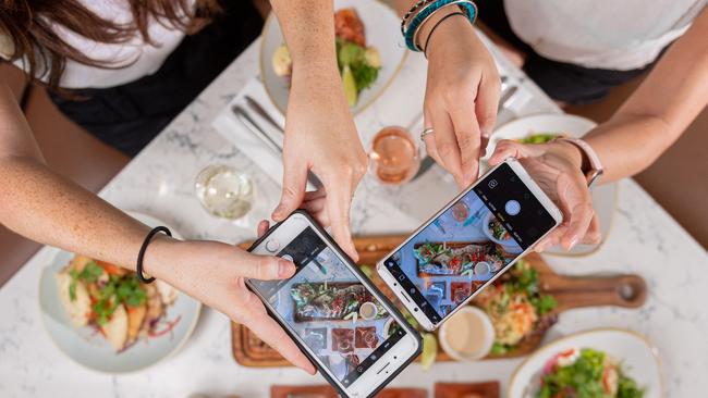 Barra is Australia's second most Instagramable food. Chef Santosh Kumar Shah knocks up barramundi spread at Snapper Rocks, Waterfront, Darwin. Including a charcoal whole caught barra with green papaya salad and cashew sauce. Alex Mowatt and Angi Troy snap a picture for the gram. Picture: Che Chorley