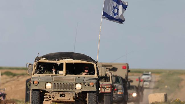 TOPSHOT - This picture taken from a position in southern Israel near the border with the Gaza Strip shows armoured personnel carriers leaving Gaza, on March 4, 2024, amid continuing battles between Israel and the Palestinian militant group Hamas. (Photo by Menahem KAHANA / AFP)