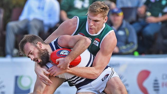 Greensborough’s Tom Bell tackles Bundoora’s Andrew Sturgess. Picture: Rob Leeson