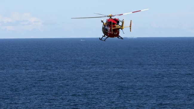 The Westpac Rescue Helicopter leaves Little Bay after it was used to winch the nine-year-old from the water after he was swept off the rocks. Picture: Damian Shaw