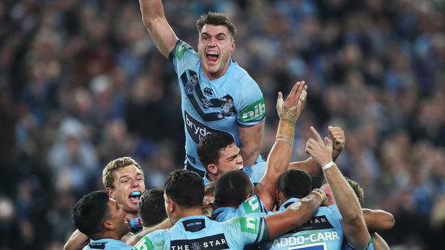 Angus Crichton rises above his Blues teammates at ANZ Stadium in Sydney last night to celebrate a historic win over Queensland and clinch the Origin series for the first time since 2014. Picture. Phil Hillyard