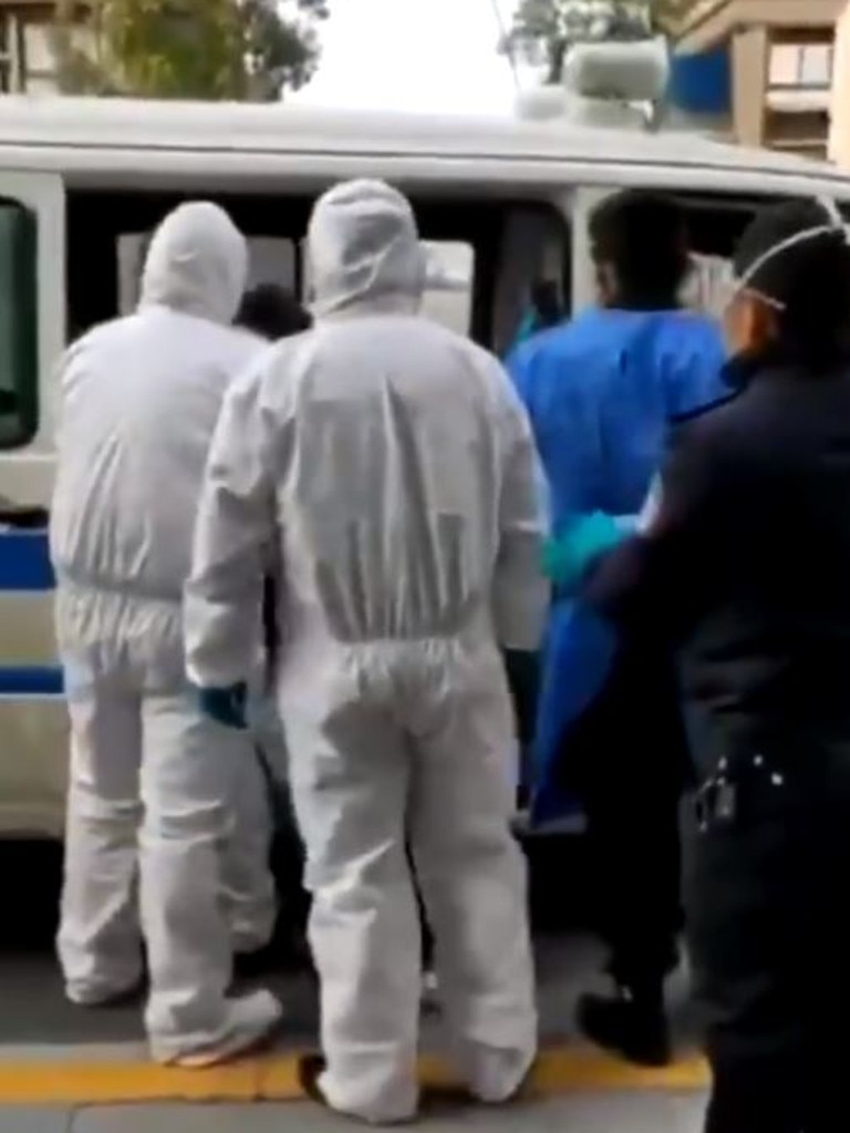 Other people in masks and full body suits can be seen watching the struggle.