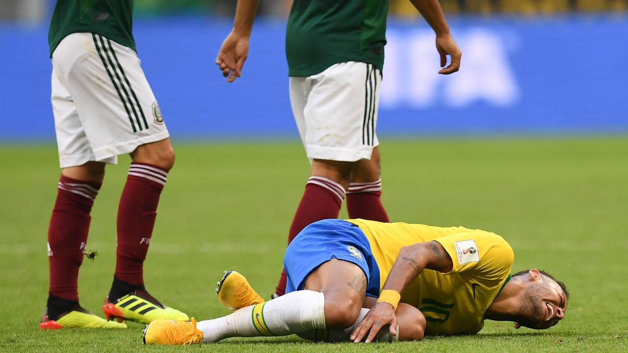 Neymar lies on the ground.
