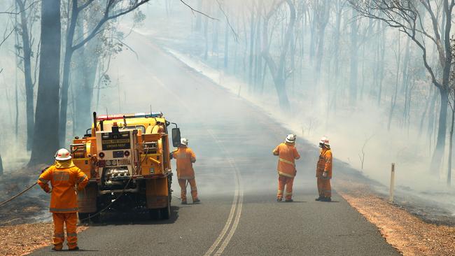 Rural Fire Brigade officers fighting a bush fire crossing near Ravensbourne. Photographer: Liam Kidston.