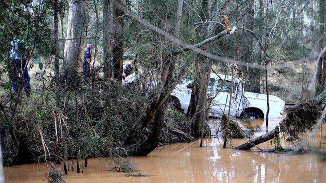 Police pull the white ute from a dam in Leppington. Picture: Stephen Cooper