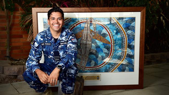 Indigenous Liaison Officer, FLT LT David Williams with Townsville artist Linda Oliver's painting. Picture: Shae Beplate.