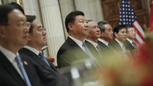 China's President Xi Jinping listens to President Donald Trump.