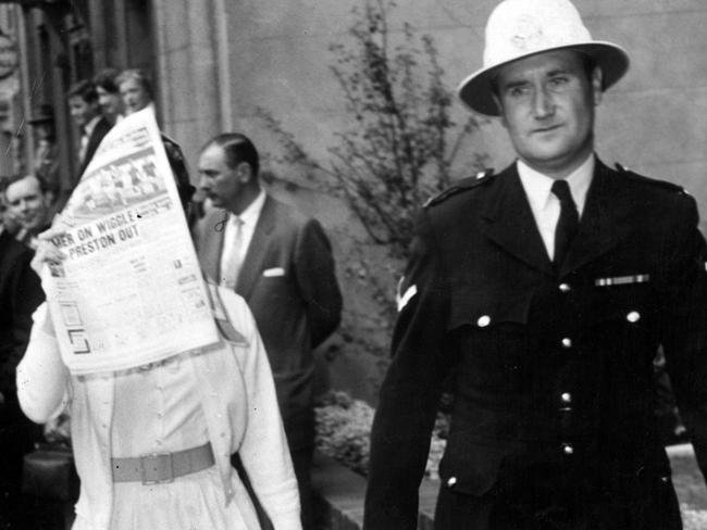 1959: Ava Gardner hides her face from disappointed fans as she leaves a restaurant in Collins St, Melbourne, with a police escort. The star was in the city to film <i>On The Beach</i> with Gregory Peck.