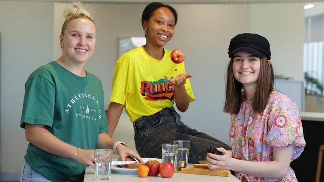 Natasha Brierley (Nursing/Paramedicine), Delphine Kawela (Business) and Anika Rossington (Midwifery), work together to make healthy choices in the kitchen on campus. Picture: Lachie Millard