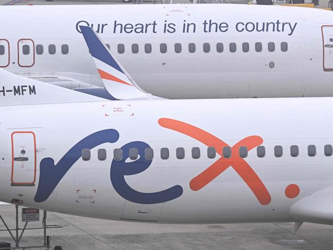 Rex Airlines Boeing 737 planes lay idle on the tarmac at Melbourne's Tullamarine Airport on July 31, 2024. The Australian regional airline Rex cancelled flights as it entered voluntary administration on July 31, leaving the fate of the country's third-largest carrier in serious doubt. (Photo by William WEST / AFP)