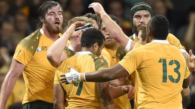 Australia's players celebrate after their number 8 David Pocock (2nd L) scored a try during a Pool A match of the 2015 Rugby World Cup between Australia and Fiji at the Millennium stadium in Cardiff, south Wales, on September 23, 2015. AFP PHOTO / DAMIEN MEYER RESTRICTED TO EDITORIAL USE, NO USE IN LIVE MATCH TRACKING SERVICES, TO BE USED AS NON-SEQUENTIAL STILLS