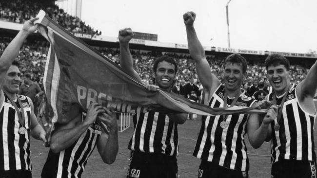 Port Adelaide’s Tim Ginever, Mark Williams, Stephen Williams and David Hutton holding the 1990 premiership flag. Picture: Ray Titus