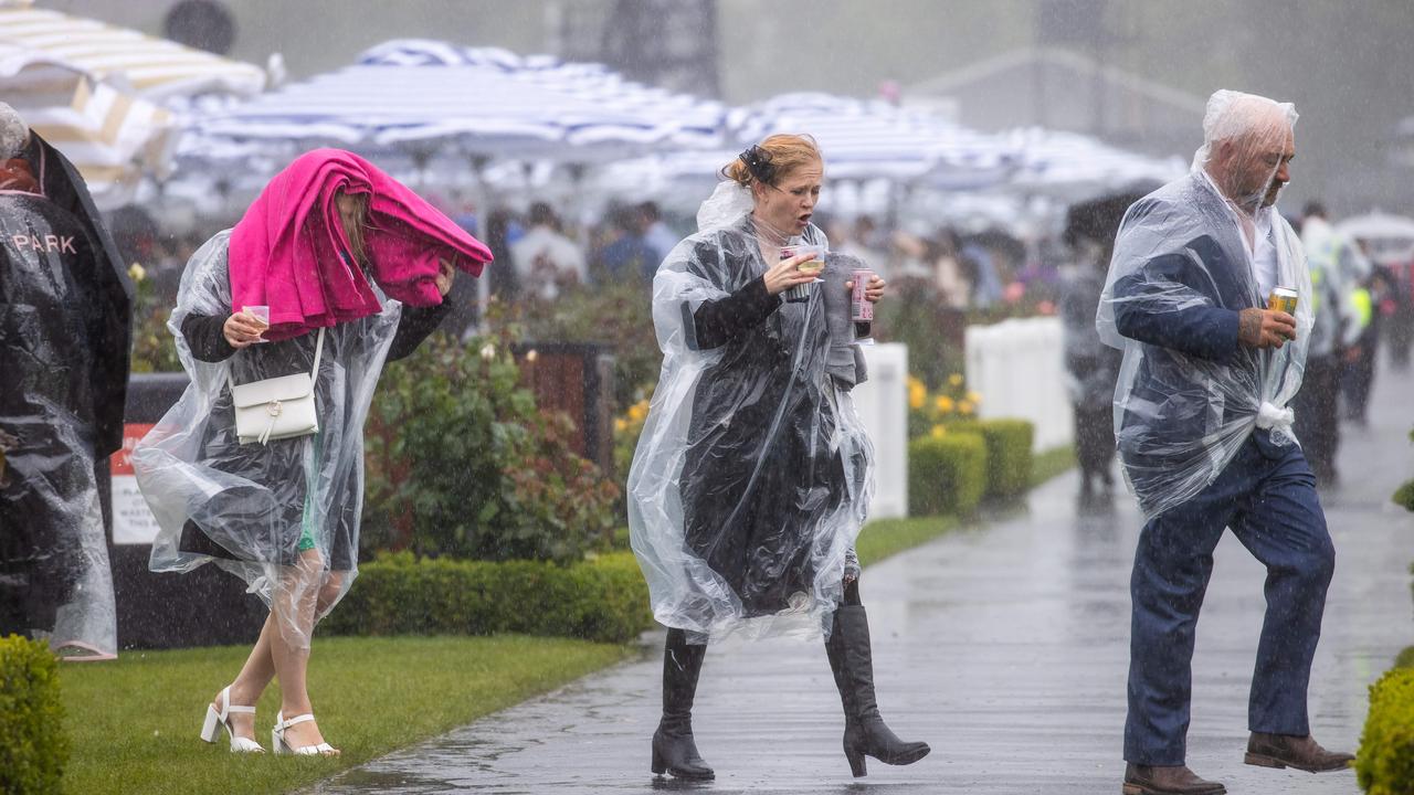 Many punters were forced to run for cover as rain descended on the field. Picture: Jason Edwards