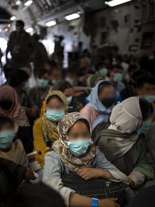 Afghan families board a rescue flight from Kabul to Australia.